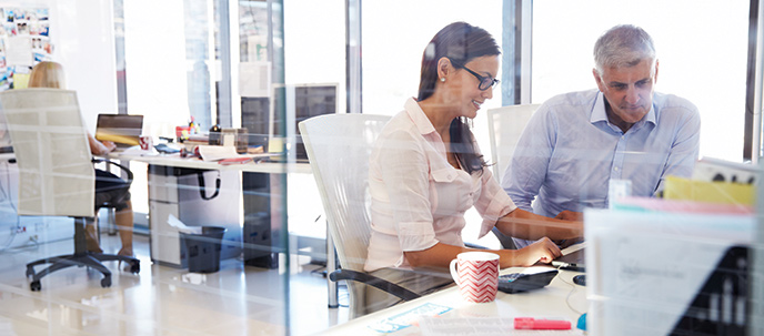 2 people talking at an office desk